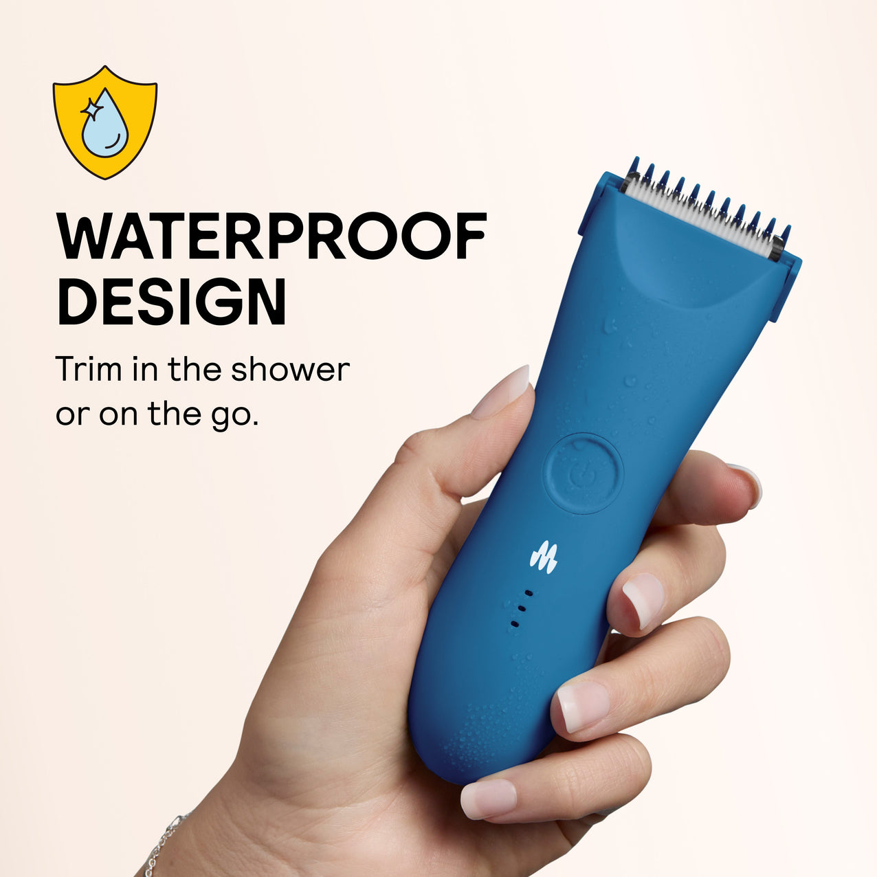 Blue handheld waterproof electric hair trimmer with ergonomic design, held in hand with water droplets on surface.