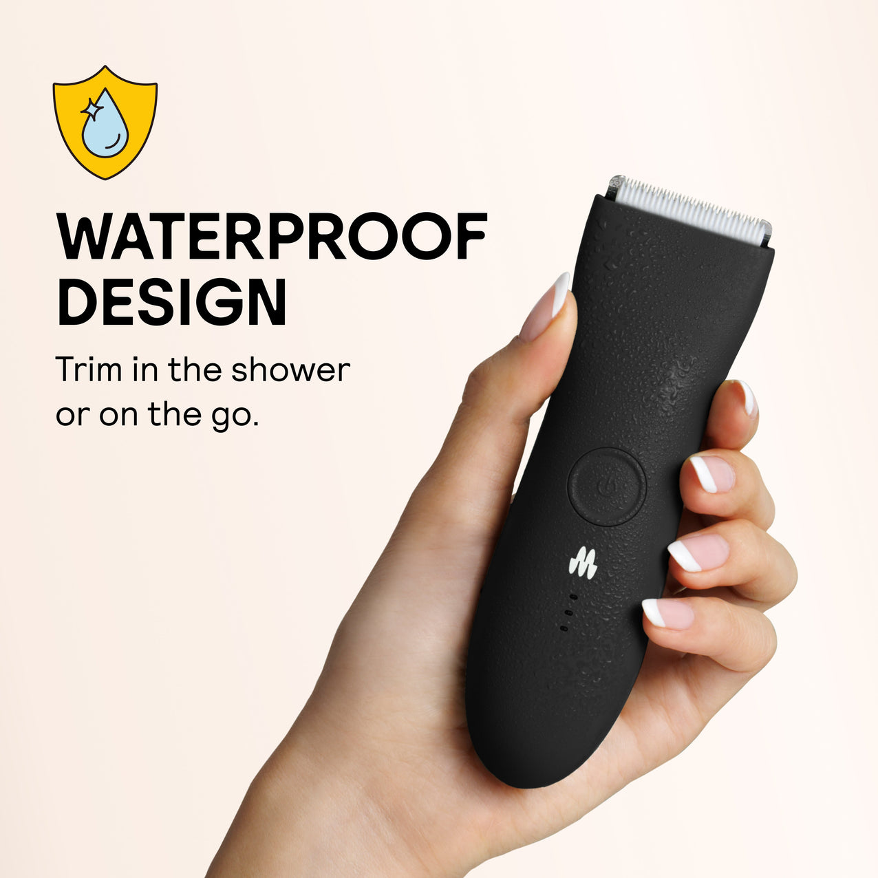 Black waterproof electric trimmer with water droplets held in hand, designed for shower and travel use.